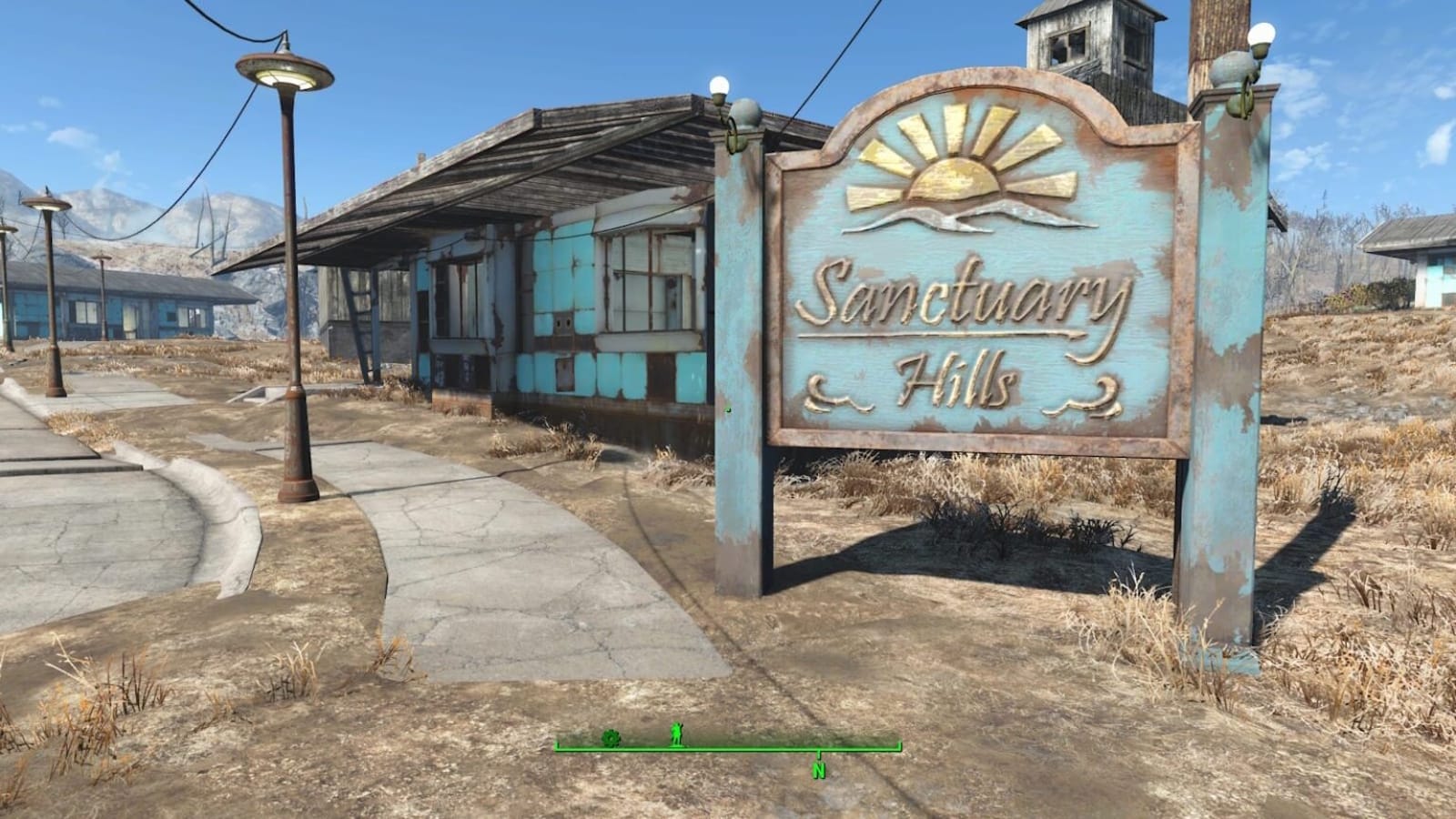 Placa envelhecida com texto ‘Sanctuary Hills’ ao lado de calçada rachada e postes enferrujados. Casas deterioradas e vegetação seca compõem o cenário, sugerindo área suburbana abandonada.