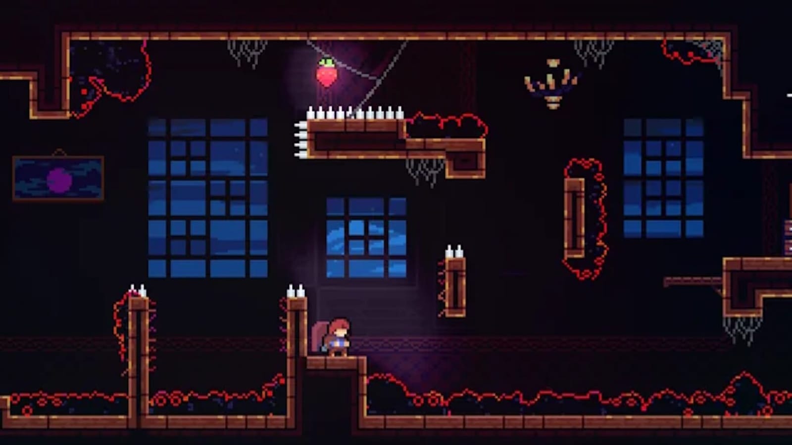 Pixel art mostrando personagem em plataforma dentro de sala escura com janelas azuis, vinhas vermelhas e espinhos. Morango colecionável flutua acima de plataforma cercada por teias. Ambiente lembra mansão abandonada com quadros e castiçais.