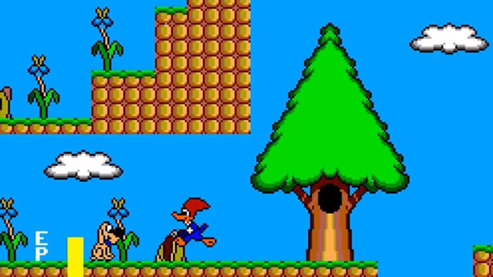 Cena pixelada com Pica‑Pau sobre grama diante de bloco marrom com padrão hexagonal. Há plantas verdes com flores azuis, árvore grande com cavidade e céu azul com nuvens.