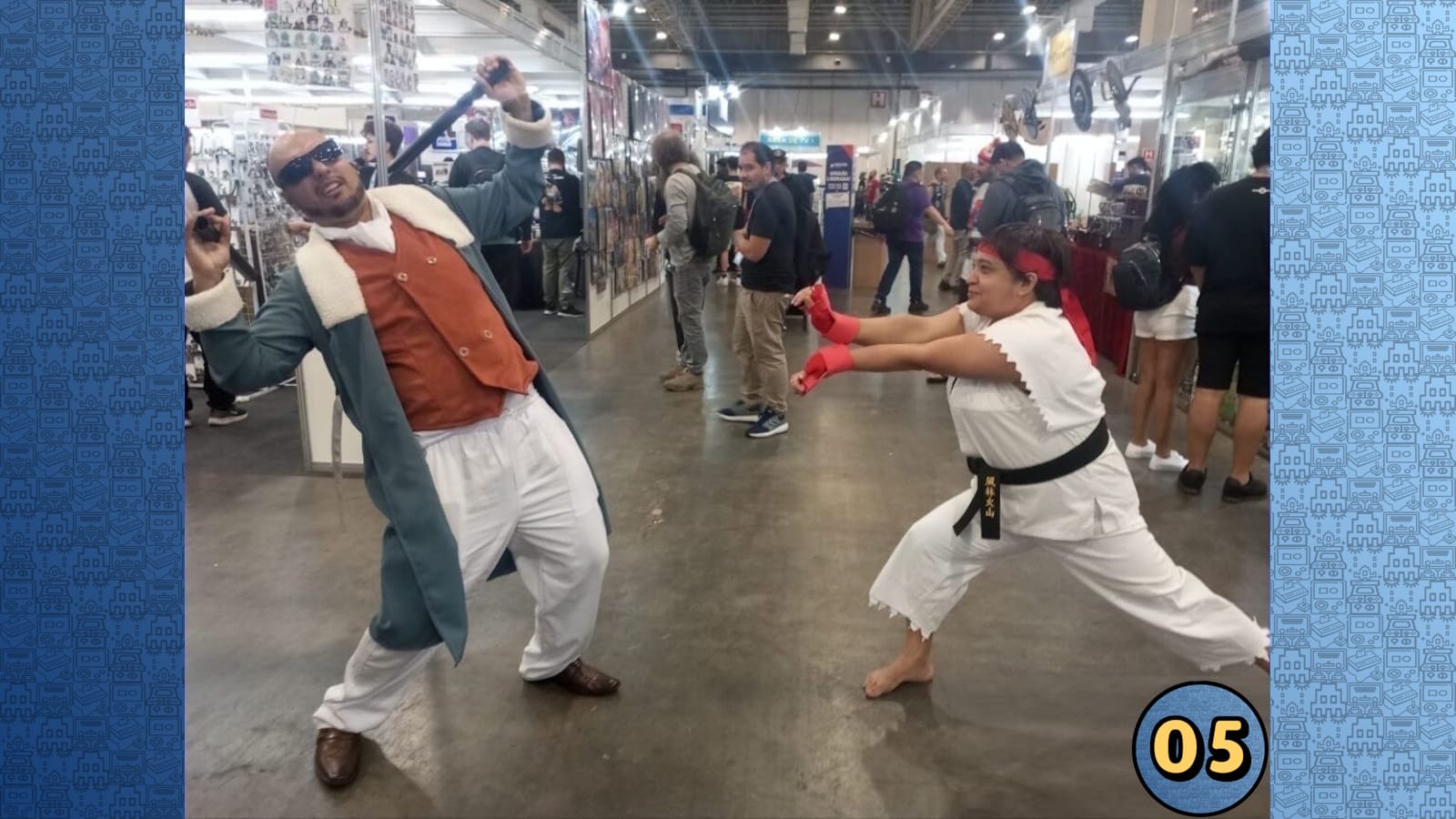Cosplayer com casaco verde‑água e óculos posa dramaticamente enquanto artista marcial de gi branco e faixa preta simula golpe em ambiente de convenção.