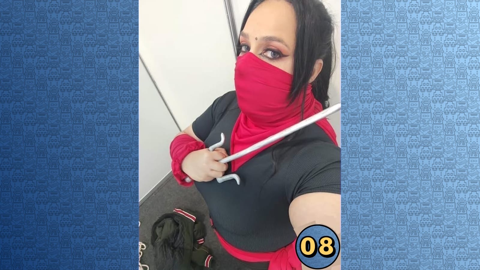 Pessoa em traje ninja preto com detalhes vermelhos, máscara cobrindo o rosto e dois sais cruzados sobre o peito.
