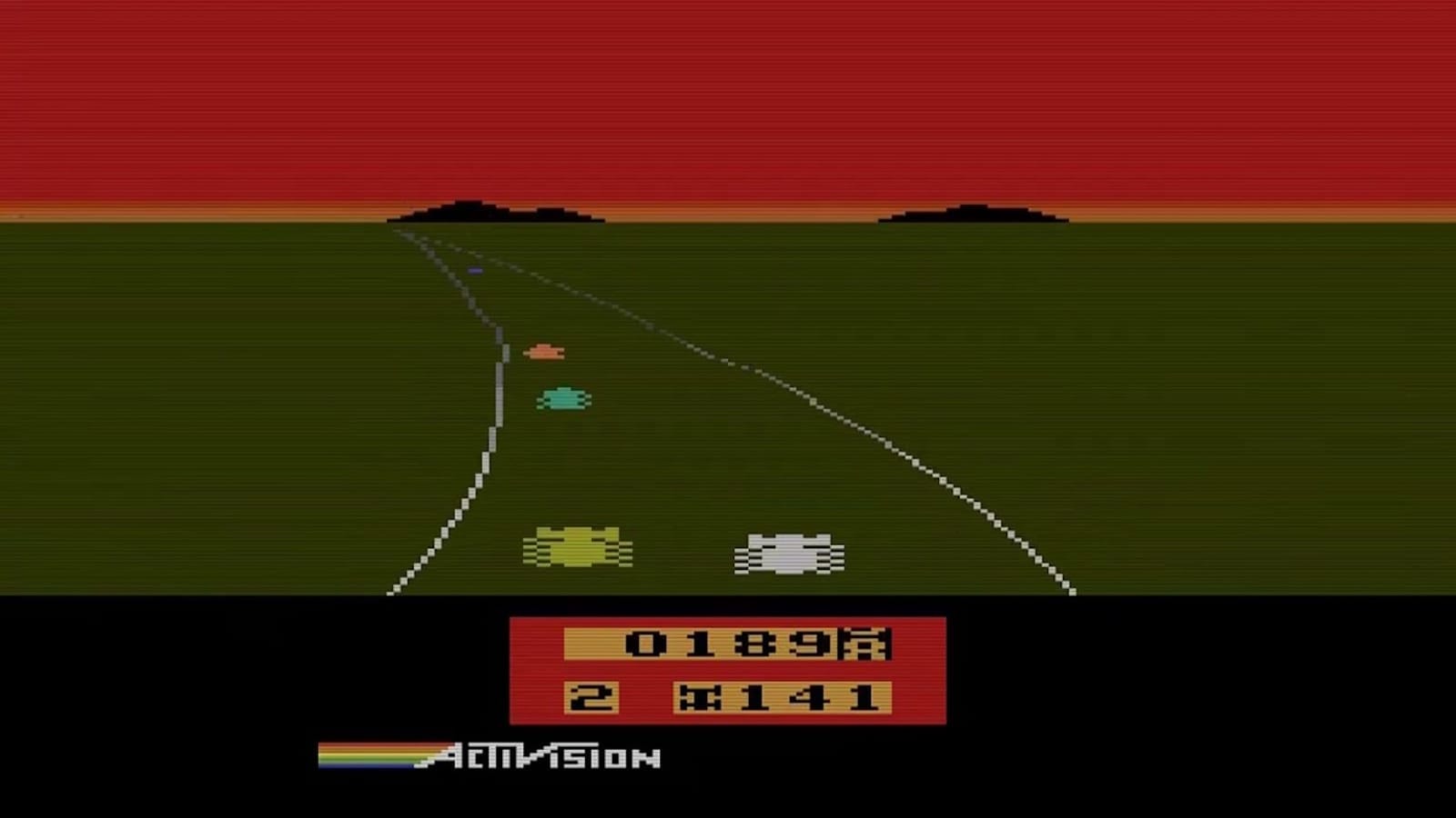 Tela de jogo de corrida Atari com estrada em perspectiva, carros coloridos avançando e logotipo Activision com faixa arco‑íris na base.