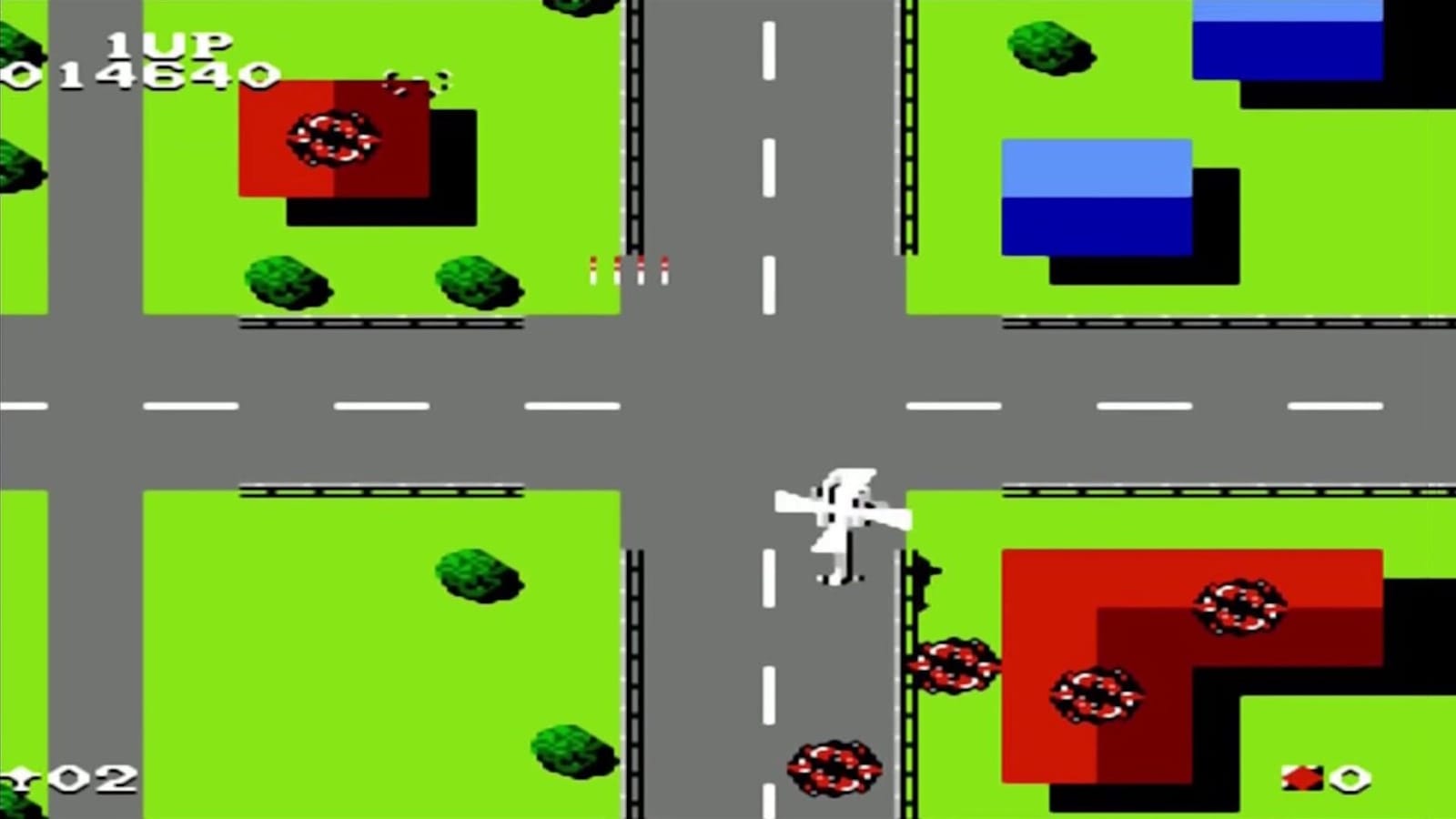 Tela de jogo retrô com visão aérea de cidade, estradas cruzadas, prédios coloridos, explosões circulares e avião branco sobrevoando o centro.