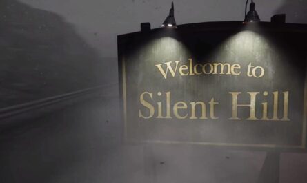 Placa iluminada por duas lâmpadas com texto ‘Welcome to Silent Hill’ diante de estrada coberta por névoa, com silhuetas de montanhas ao fundo em clima sombrio.